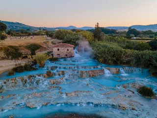 Fotobehang natural spa with waterfalls and hot springs at Saturnia thermal baths, Grosseto, Tuscany, Italy,Hot springs Cascate del Mulino man and woman in hot spring taking a dip during morning with fog © Fokke Baarssen