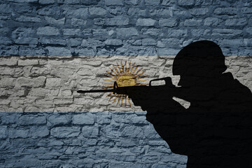 Soldier silhouette on the old brick wall with flag of argentina country.