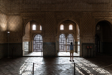 Girl enjoying the light of the Alhambra in Granada. - obrazy, fototapety, plakaty