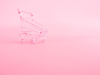 shopping and payment concept from small trolley on pink pastel color background.