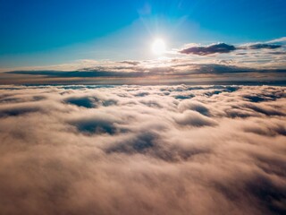 High flight over the fog in the mountains. Ukrainian Carpathians in the morning. Aerial drone view.