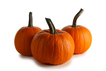 Three orange pumpkins on white