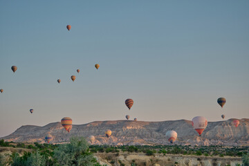 Fototapeta na wymiar 21.7.2021. Goreme Cappadocia, Turkey. Hot air balloons, Groups of of hot air balloon in Cappadocia, Urgup when sun rises and small hill.
