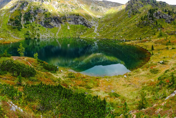 reflections from the mountains in a clear cold mountain lake in austria panorama
