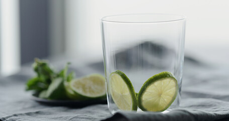 lime slices in tumbler glass on linen cloth