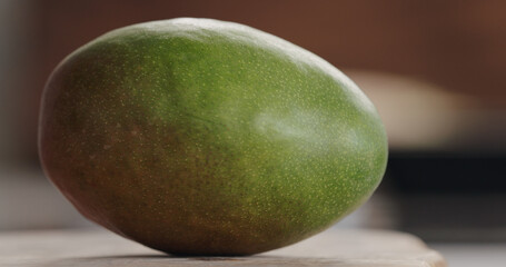 ripe green mango on olive wood board