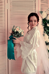 A young bride in a silk robe is preparing for the wedding during the morning gathering