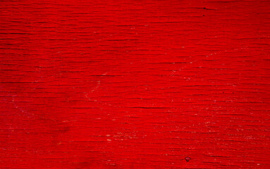 Shabby red paint on a wooden surface.