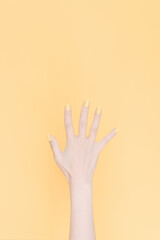 hand showing number five In front of the yellow background,