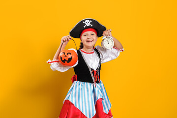 Halloween. Little child in a carnival costume of a pirate on a yellow background. Little girl...