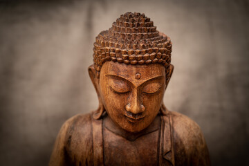 wooden buddha on grey background