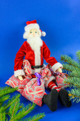 Santa Claus in fir branches on a blue background.