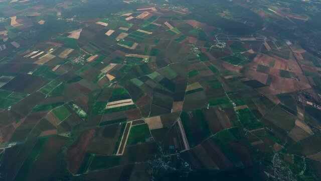 High altitude airplane view of French countryside rural area showing agricultural fields meadows and two small villages moving fast over the open and flat landscape 4k resolution quality animation