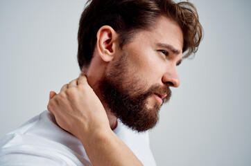 emotional man in a white t-shirt stress medicine pain in the neck studio treatment