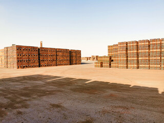 bundles of red bricks kept inside a factory and ready to transport