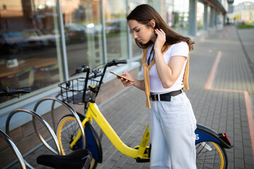 Obraz premium Caucasian young woman pays for bike rental in app