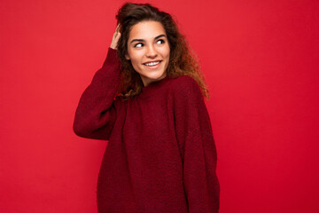 Shot of attractive happy smiling young woman wearing casual outfit standing isolated over colourful background with empty space looking to the side