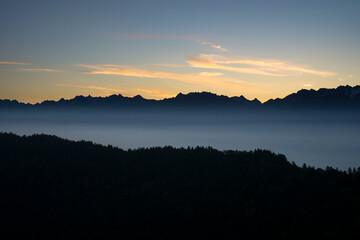 Sea of clouds and mountains silhouettes in the morning