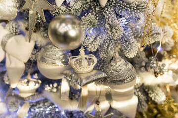 Close up of holidays location with toys, garlands and white crown on Christmas tree