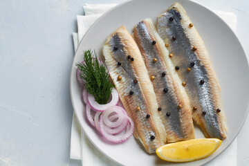 salted fillet of herring decorated with dill pepper lemon red onion