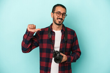 Young caucasian photographer man isolated on blue background feels proud and self confident, example to follow.