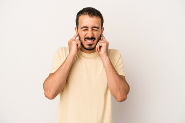 Fototapeta premium Young caucasian man isolated on white background covering ears with hands.