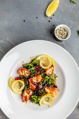 Fish salad salmon, lettuce greens and lemon. vertical image. top view. place for text