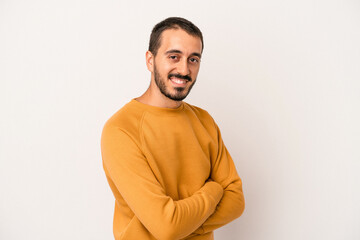 Young caucasian man isolated on white background who feels confident, crossing arms with determination.