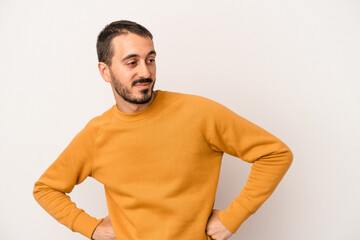 Young caucasian man isolated on white background laughs happily and has fun keeping hands on stomach.