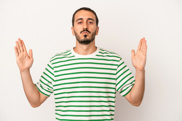 Young caucasian man isolated on white background holding something little with forefingers, smiling and confident.