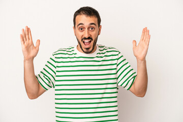 Young caucasian man isolated on white background receiving a pleasant surprise, excited and raising hands.