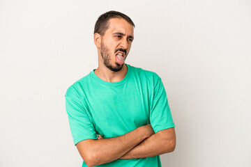 Fototapeta premium Young caucasian man isolated on white background funny and friendly sticking out tongue.