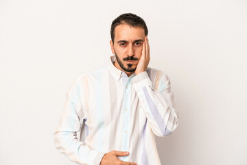 Young caucasian man isolated on white background blows cheeks, has tired expression. Facial expression concept.