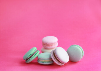 Obraz na płótnie Canvas Macaron or macaroon on pink background, colorful almond cookies with different fillings