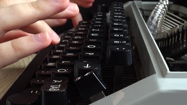 The girl is typing on a retro typewriter.