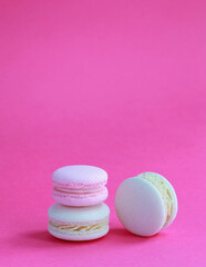 Macaron or macaroon on pink background, colorful almond cookies with different fillings