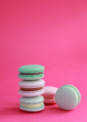 Macaron or macaroon on pink background, colorful almond cookies with different fillings
