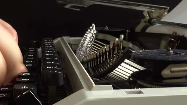 The man is typing on a retro typewriter.