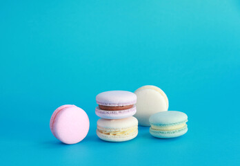 Macaron or macaroon on turquoise background, colorful almond cookies with different fillings