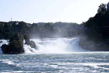Famous Rhine Falls with rocks and trees on a beautiful autumn day. Photo taken September 25th, 2021, Zürich, Switzerland.