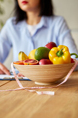 Nutritionist, dietitian woman writing a diet plan, with healthy vegetables and fruits