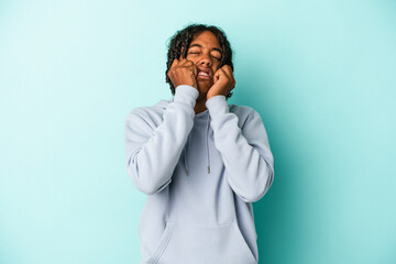 Young african american man isolated on blue background crying, unhappy with something, agony and confusion concept.