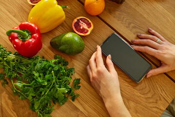 Woman is using digital tablet or smarthone, looking recipe