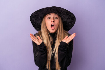 Young Russian woman disguised as a witch celebrating Halloween isolated on purple background surprised and shocked.