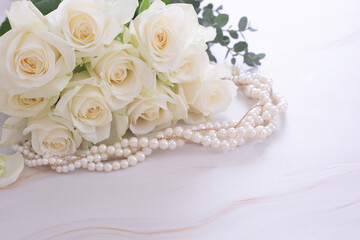 Obraz na płótnie Canvas 白い薔薇の花束と真珠のネックレス