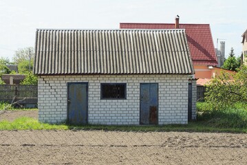 one white brick country house with two doors and a small window under a gray slate roof outside