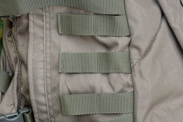 three green harness stripes on the gray fabric of the backpack
