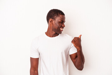 Young African American man isolated on white background points with thumb finger away, laughing and carefree.