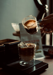 espresso shot dropping in a glass with digital coffee scale