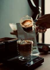 espresso shot dropping in a glass with digital coffee scale